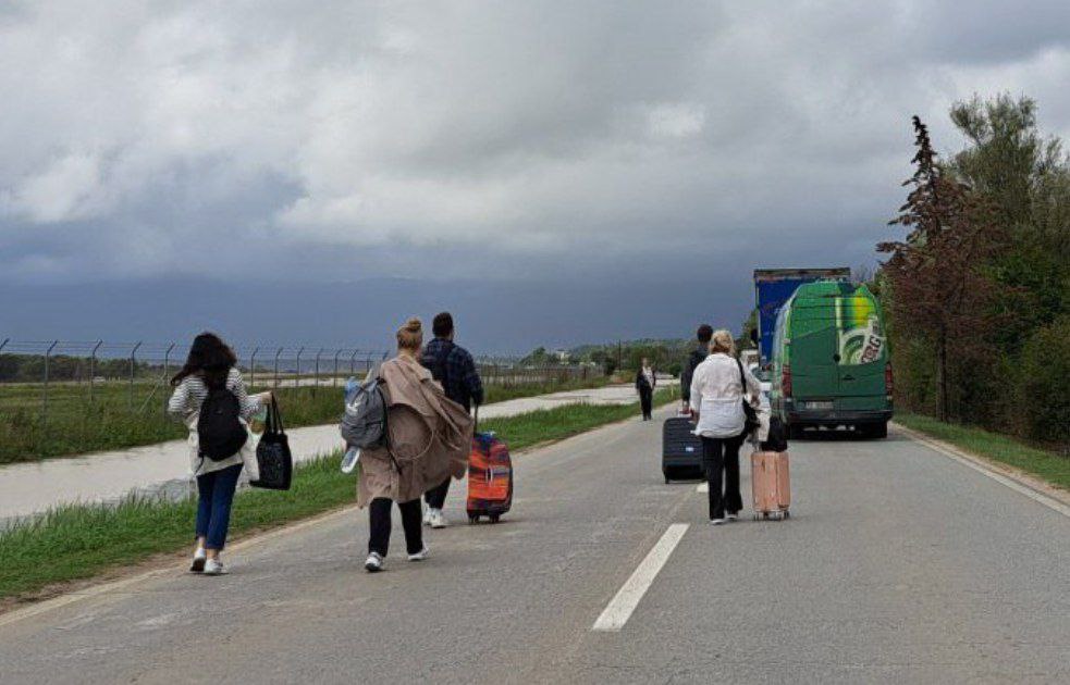 Туристы идут пешком по дороге в аэропорт Тивата