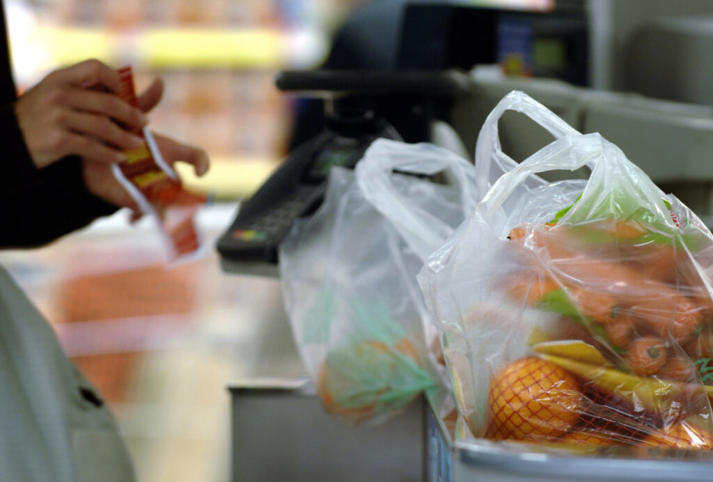 Пакеты с продуктами внутри на кассе магазина