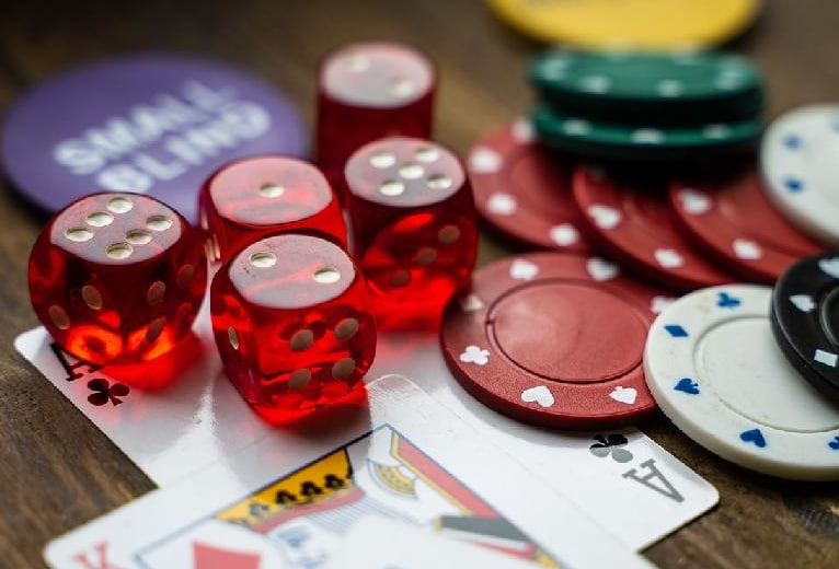 Игральные кости, карты и фишки из покера на столе