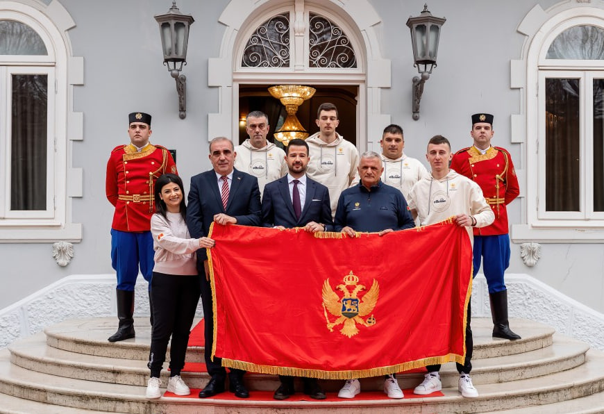 Президент Черногории Яков Милатович, совместно с членами олимпийской команды, держит государственный флаг